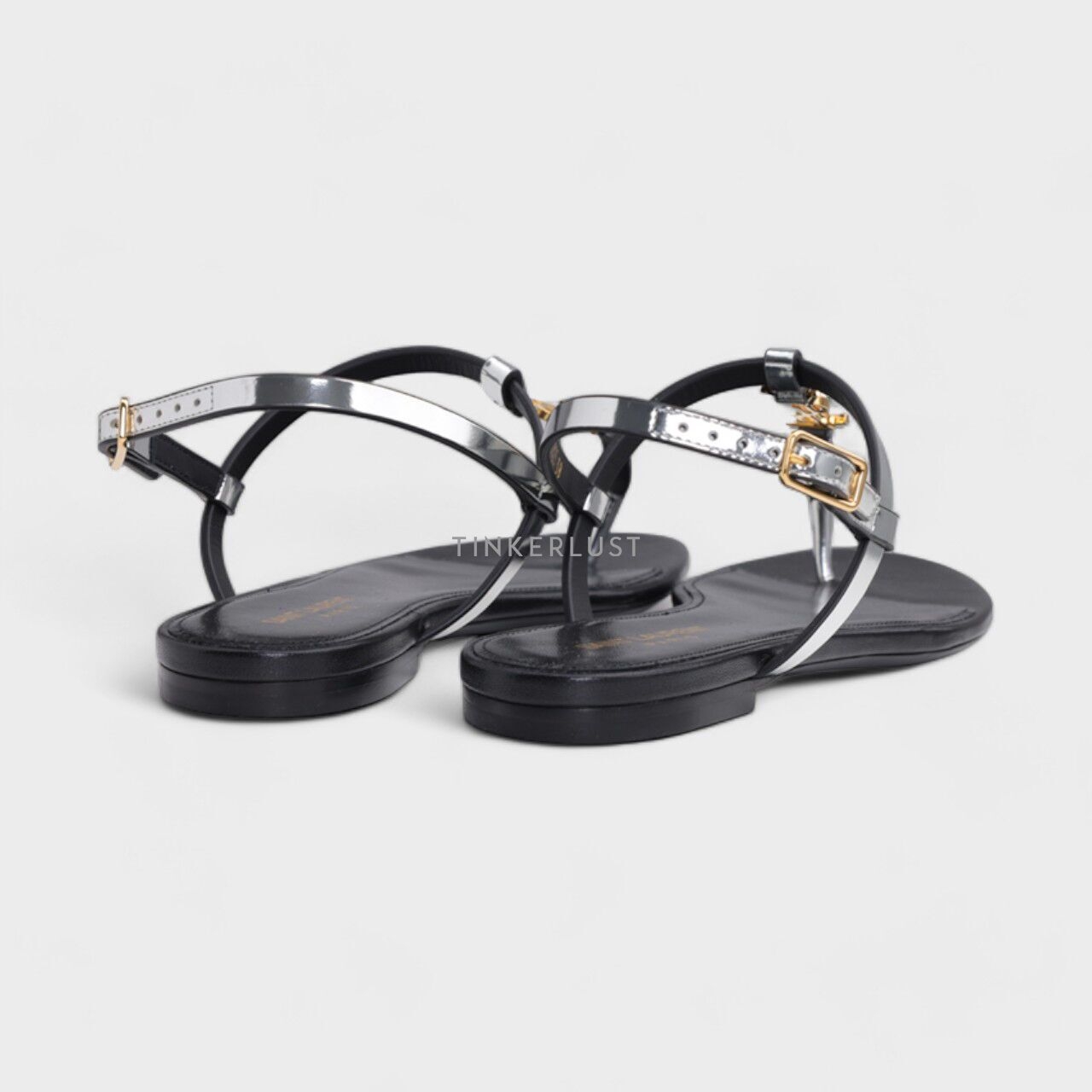 Saint Laurent Women Cassandra Flat Ankle Strap Sandals in Argent Reflective Leather with Gold-Tone Monogram